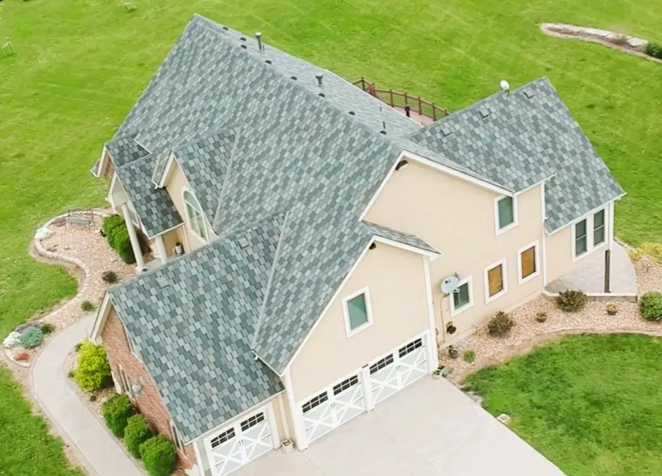 Aerial view of a large home featuring a multi-layered grey architectural shingle roof.