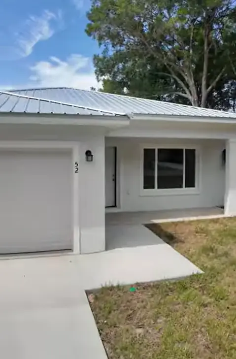 Modern white Florida home featuring a newly installed silver metal panel roofing system