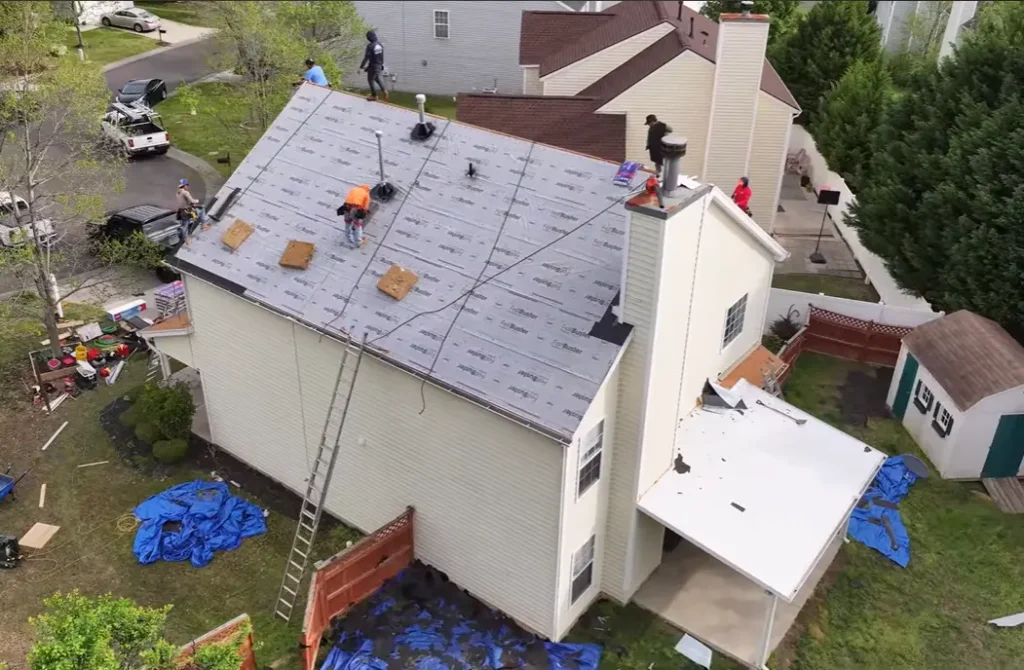Newly installed architectural asphalt shingles on a white residential house.