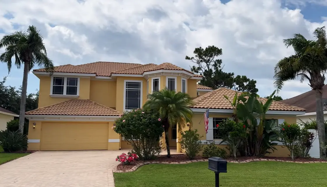 Two-story yellow home with a Mediterranean-style clay tile roof in Central Florida