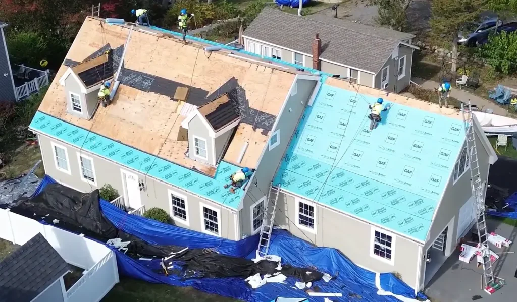 Roofing crew installing blue synthetic underlayment on a residential home in Gainesville for superior moisture protection
